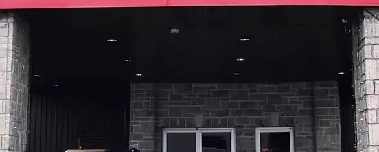 Stone-pillared entrance of the Playground Poker Club in Kahnawake under its PLAYGROUND POKER sign, photographed in 2018